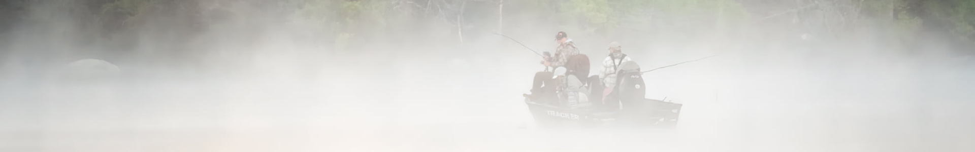 Men fishing on a boat in a foggy lake