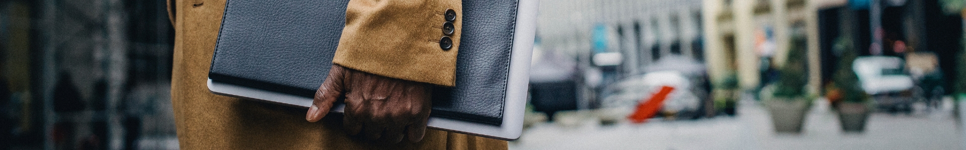 Man holding folio walking down the street