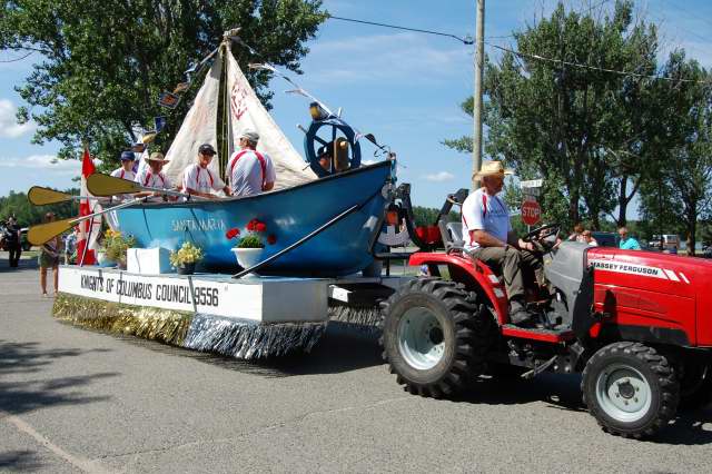 <div class="text-large">a red tractor pulling a blue boat with two people on it</div>