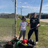a kid and an adult with baseball bats posing for the camera
