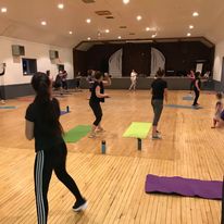 people with yoga mats in an empty auditorium
