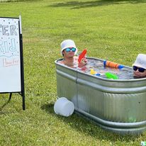 2 people soaking in a steel tub outside