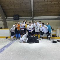 group of people in hockey uniforms posing for the camera