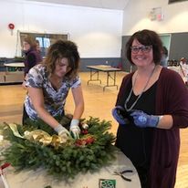 two women making a wreath