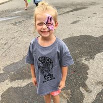 little girl with face paint wearing a gray oversized shirt