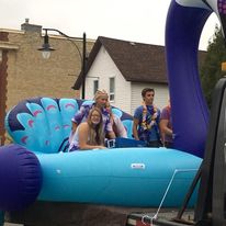 float of a peacock with 2 women and 1 man riding inside
