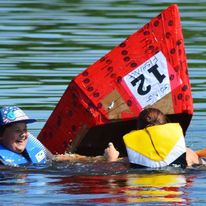 2 kids in the water beside a sinking boat