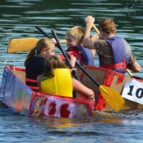2 boats with 2 kids on each boat rowing