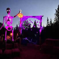 neon lights on an archway with a giant skeleton beside it