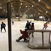 hockey rink with 7 players and 1 goalie