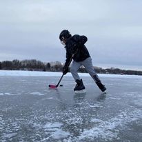 1 kid playing hockey outside